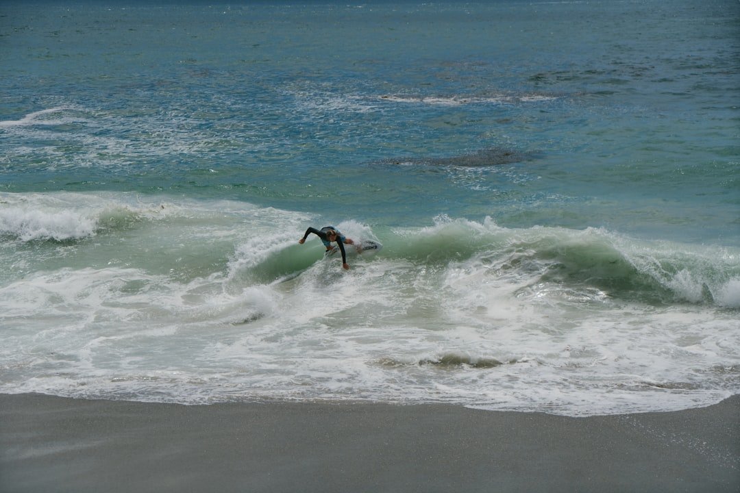 man surfing on sea waves during daytime